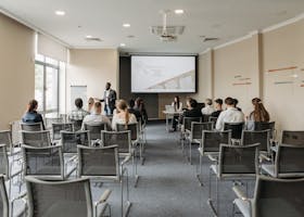 A group attending a business presentation in a modern conference room with projector.